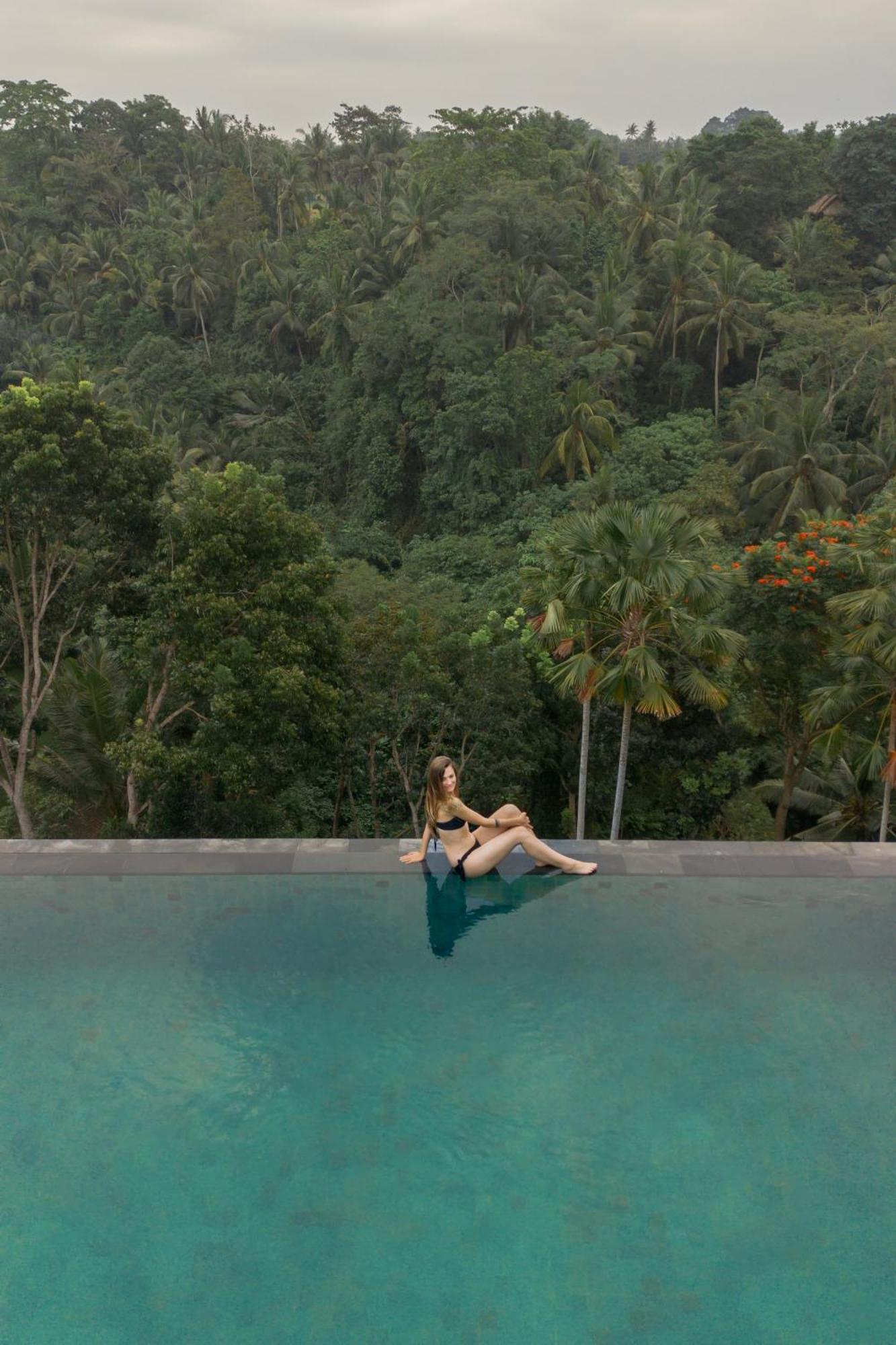 Goya Boutique Resort Убуд Екстериор снимка A woman sitting on the edge of a swimming pool